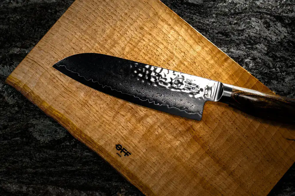 A balanced chef's knife resting on a wooden board